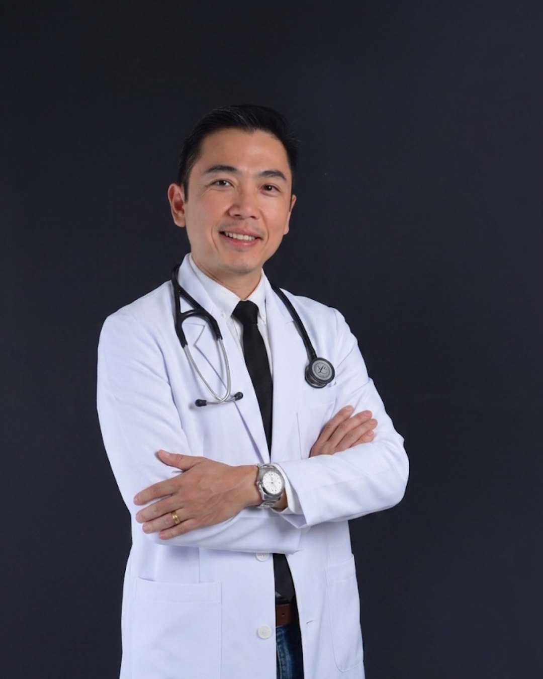 Dr. Hiroki Shinkai de jaleco branco com estetoscópio, braços cruzados